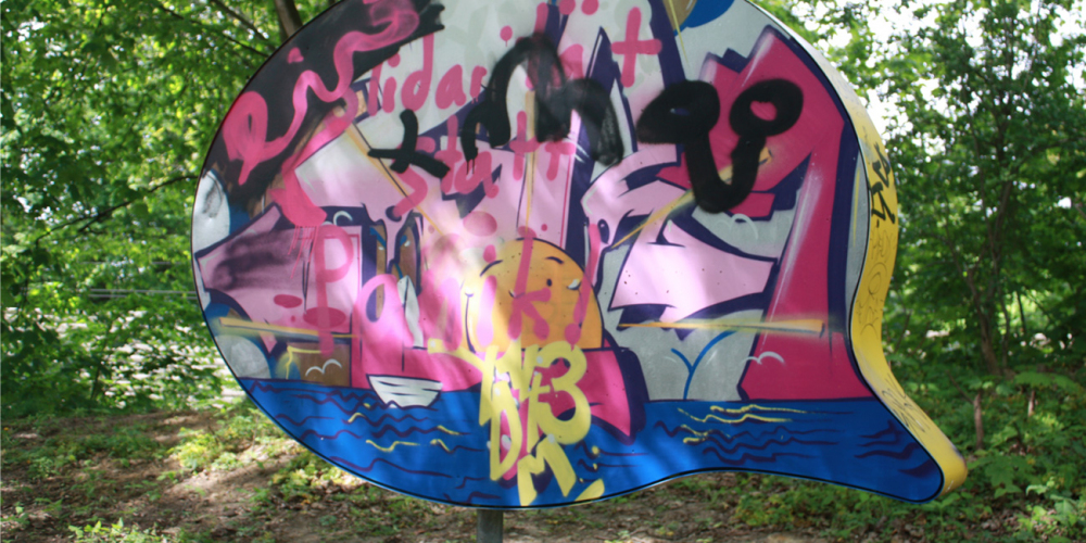 Eine mit Graffitti bunt besprühte Skulptur in Form einer Sprechblase in einem Grünzug in Horn